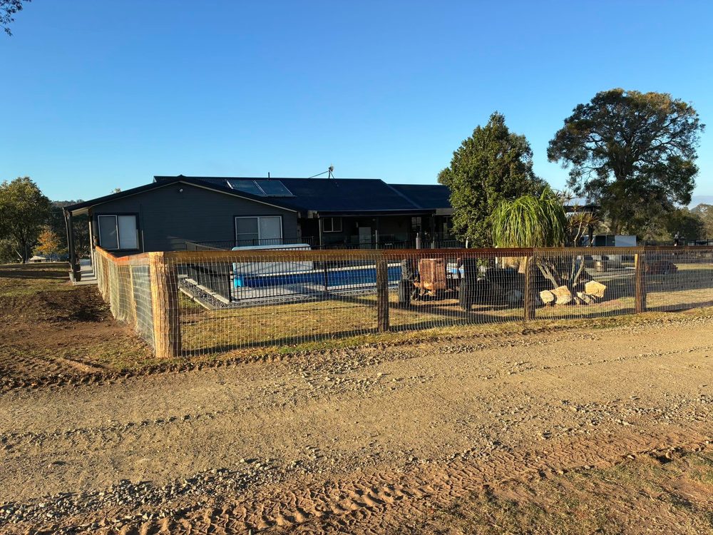 Long run of post and rail with mesh along a driveway
