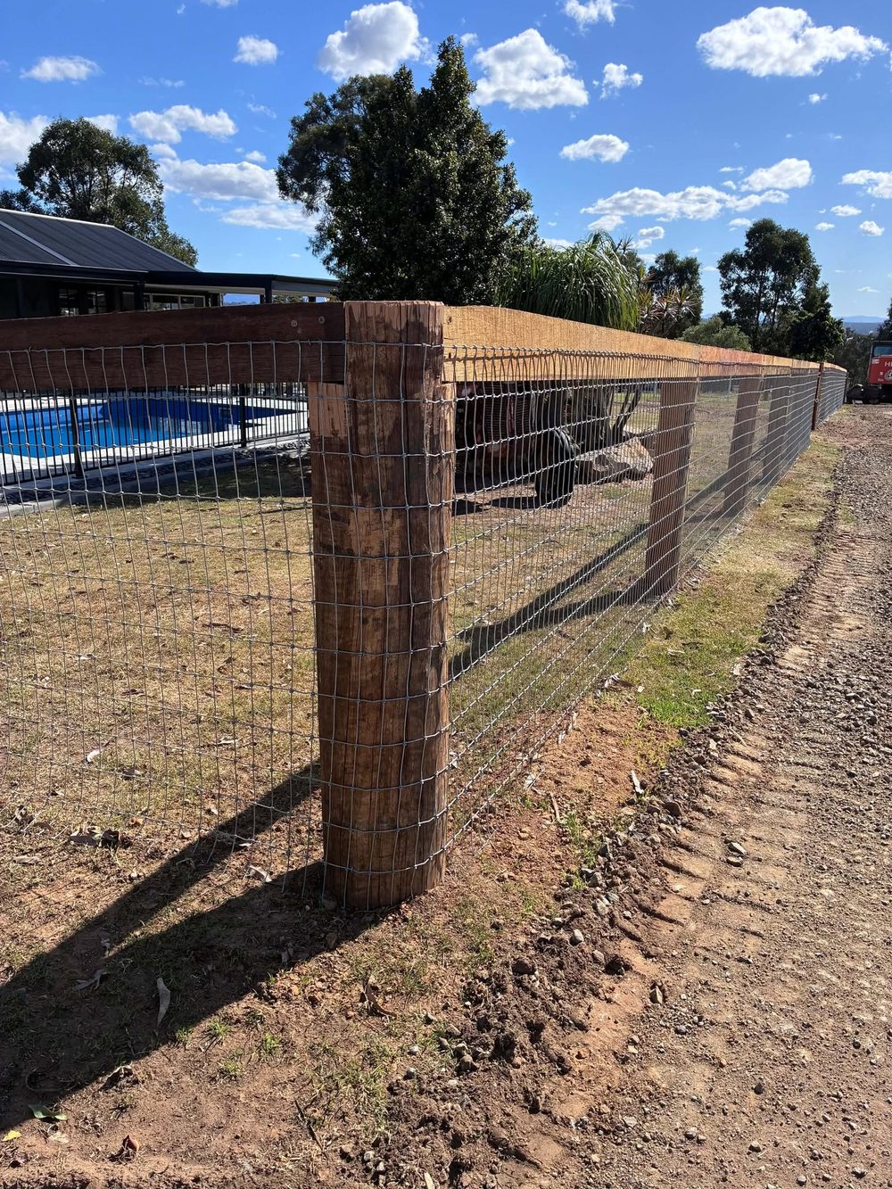 Hardwood post and rail fence with mesh