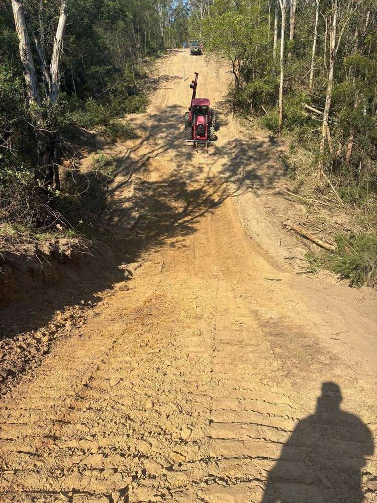 Tractor post driver working up a freshly cleared hillside line